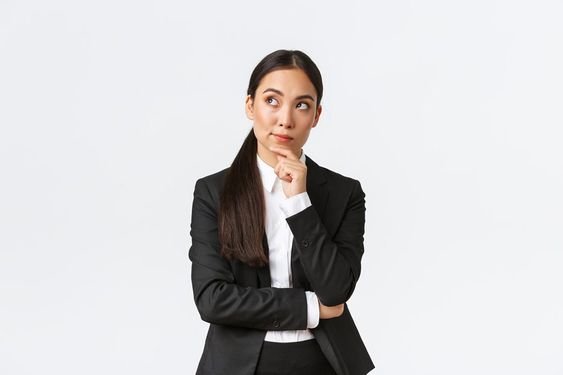  professional woman in a suit ponders, reflecting on a decision.