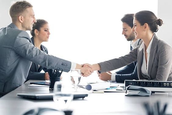 Business professionals shaking hands at a meeting, symbolizing collaboration and successful partnerships.